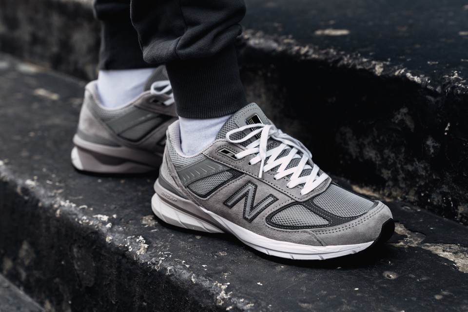 Photo d'une paire de baskets New Balance 990 grises, portées par un adolescent