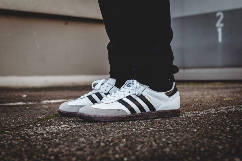 Photo d'une paire de baskets Adidas Samba blanches, portées par un adolescent