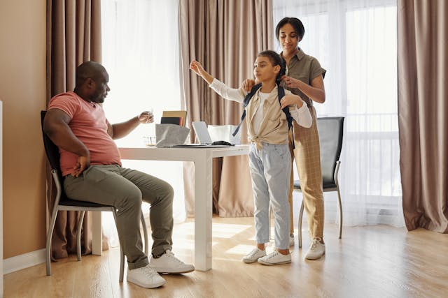 Une maman aidant sa fille à se préparer.