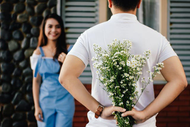Un jeune homme offrant des fleurs à son amoureuse.