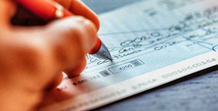 Une grand-mère remplissant un chèque pour son petit fils.